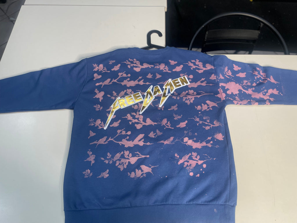 Blue shirt with pink floral pattern and visible brand logo on a white surface.